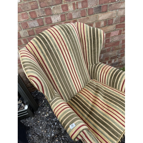 40 - A modern wing back armchair  with striped upholstery together with matching footstool