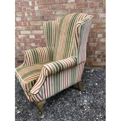 40 - A modern wing back armchair  with striped upholstery together with matching footstool