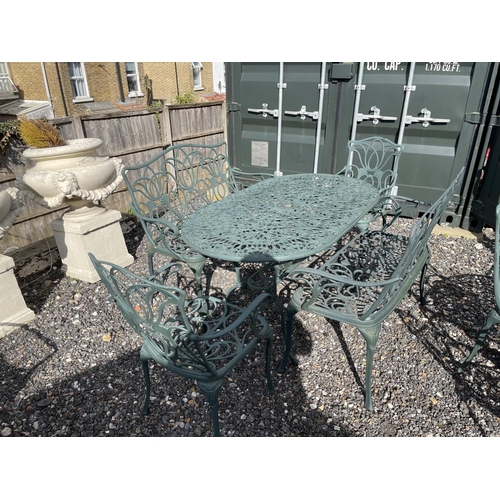 51 - A green aluminium oval garden table togther with two benches and two carver chairs 140x80