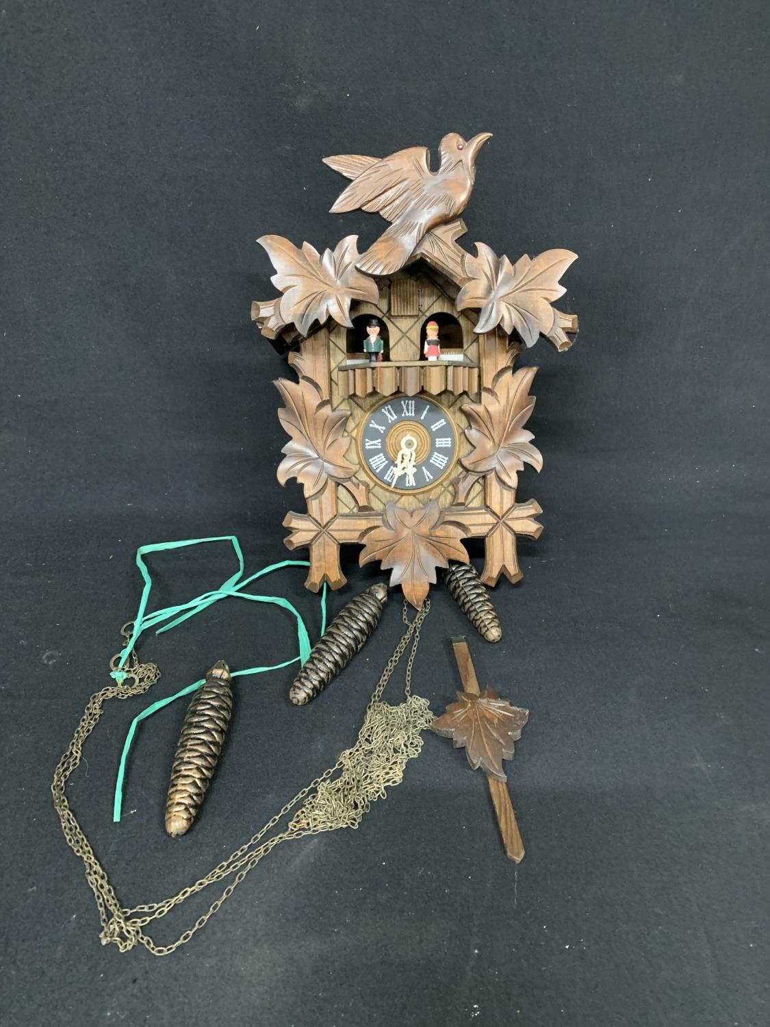 Wooden cuckoo clock with weights and chains