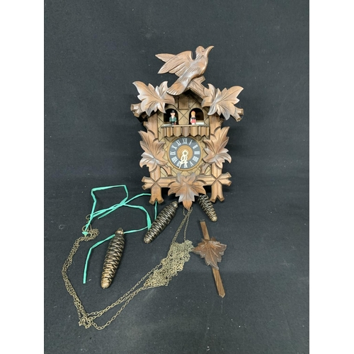 Wooden cuckoo clock with weights and chains