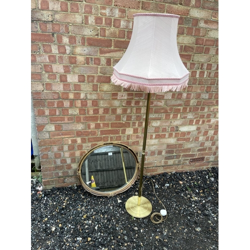 91 - A gilt mirror and a brass standard lamp with shade