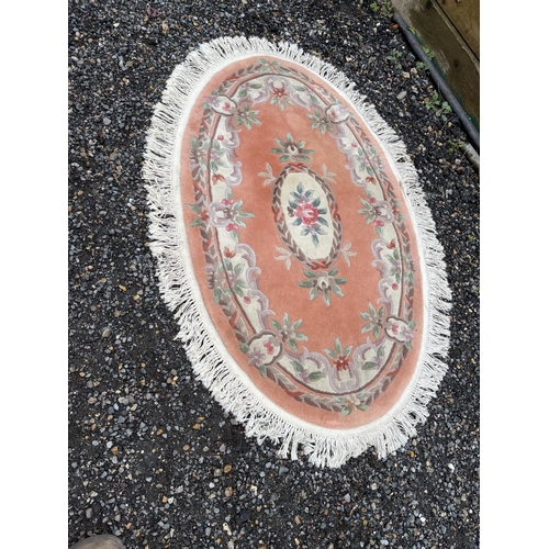 94 - An oval peach coloured chinese rug 160x100