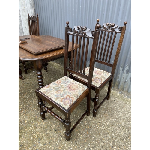 219 - A early 20th century oak wind out table (one leaf) together with four matching oak dining chairs