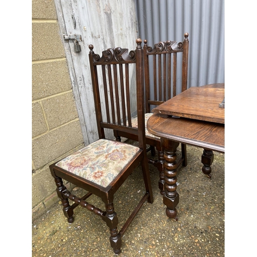 219 - A early 20th century oak wind out table (one leaf) together with four matching oak dining chairs