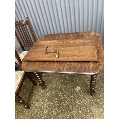 219 - A early 20th century oak wind out table (one leaf) together with four matching oak dining chairs