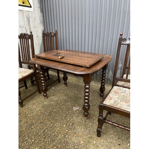 219 - A early 20th century oak wind out table (one leaf) together with four matching oak dining chairs