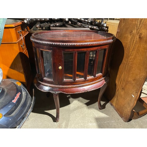 220 - An oval glazed hardwood drinks cabinet 75x 49x77