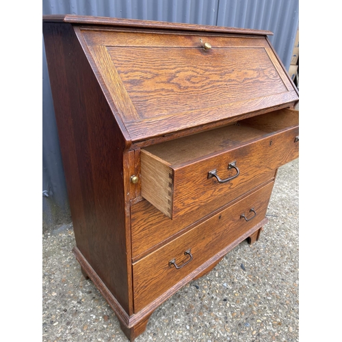 138 - An arts and crafts oak bureau with fitted interior