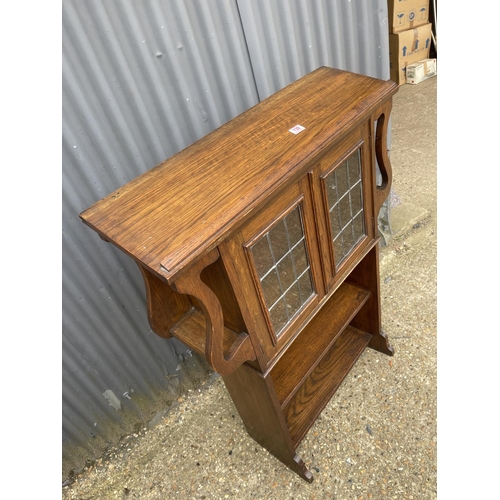 139 - An arts and crafts oak bookcase with leaded glass doors 93x30x120