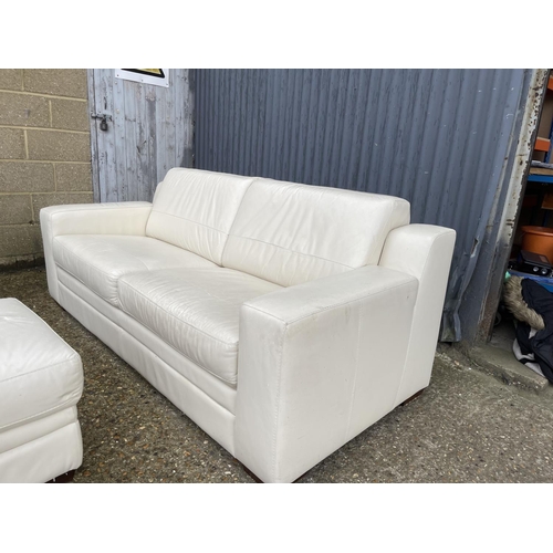 14 - A modern white leather sofa together with matching ottoman footstool