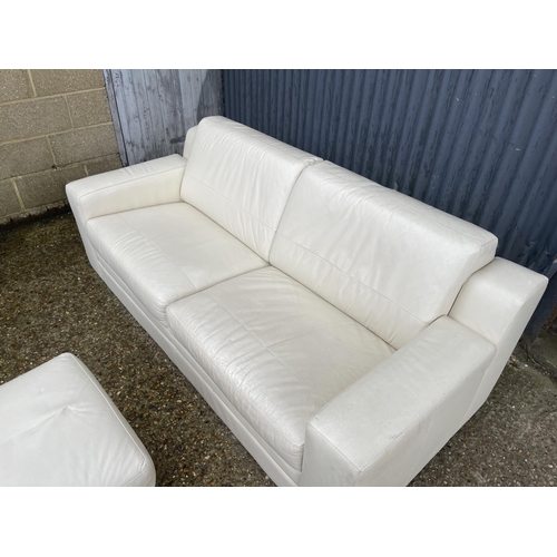 14 - A modern white leather sofa together with matching ottoman footstool