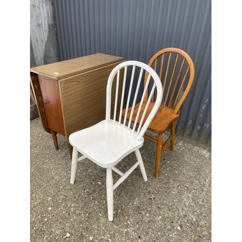 160 - A formica drop leaf table together with two stick back chairs