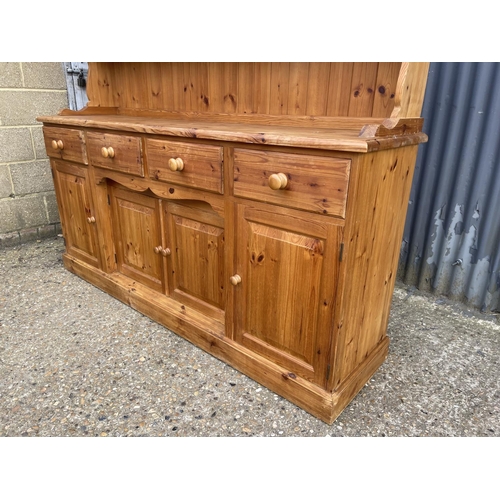 235 - A large solid far,house style pine four drawer dresser with glazed plate rack top 184x46x190