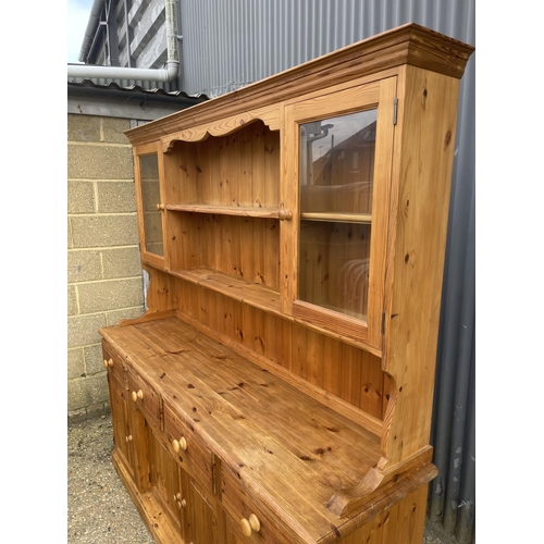 235 - A large solid far,house style pine four drawer dresser with glazed plate rack top 184x46x190