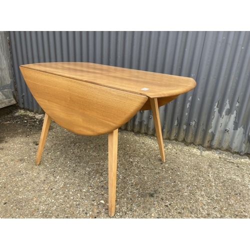 25 - An ercol light elm drop leaf kitchen table