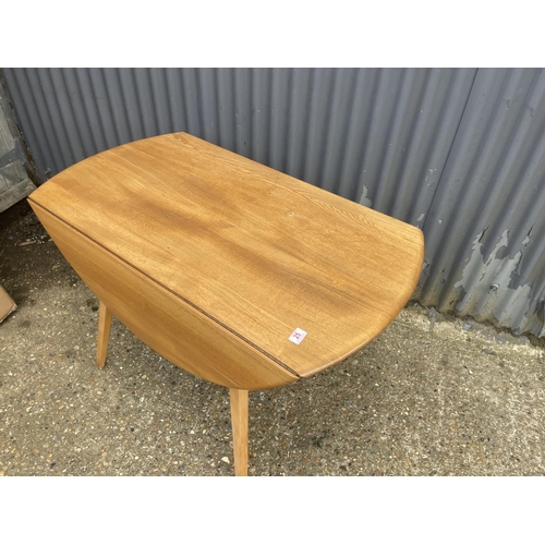 25 - An ercol light elm drop leaf kitchen table