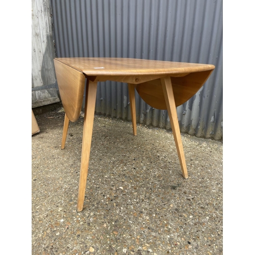 25 - An ercol light elm drop leaf kitchen table