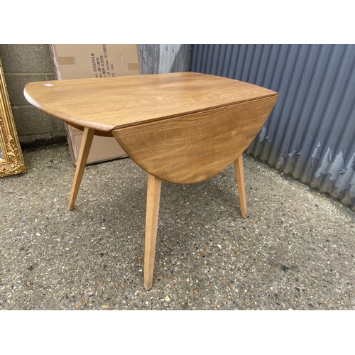 25 - An ercol light elm drop leaf kitchen table