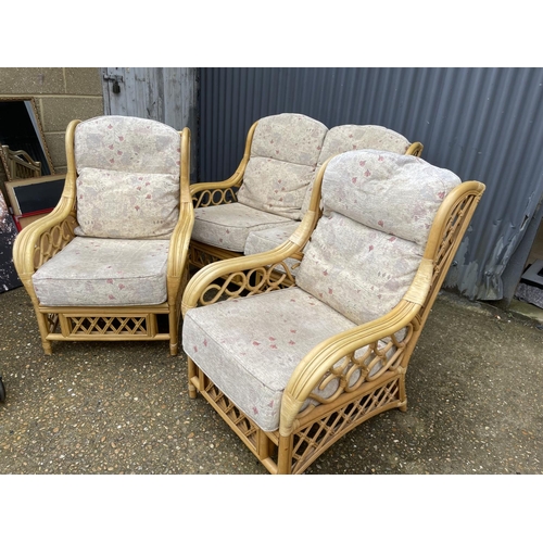 263 - A bamboo and wicker three piece conservatory suite consisting of two seater sofa and two chairs