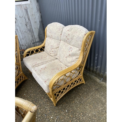 263 - A bamboo and wicker three piece conservatory suite consisting of two seater sofa and two chairs