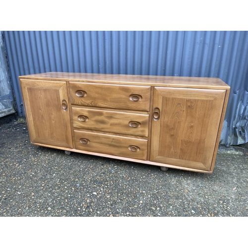 267 - An Ercol light elm three drawer and two door sideboard