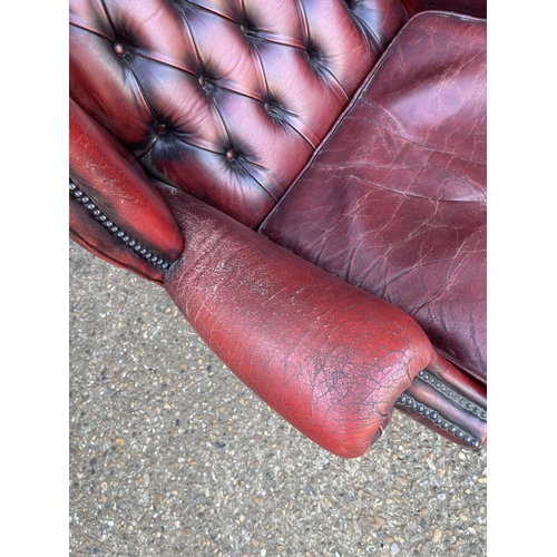 293 - An oxblood red leather chesterfield wing arm chair AF