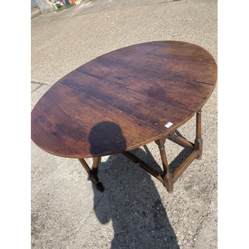 297 - An 18th century oak drop leaf table with drawer to either end 137 diameter