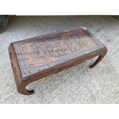 298 - An oriental coffee table with drop in glass top