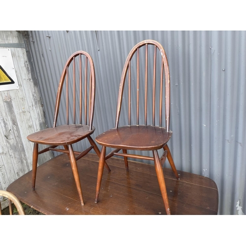 3 - An ercol elm refectory style table together with four stick back chairs