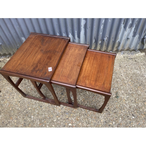 31 - A mid century teak nest of three