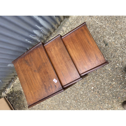 31 - A mid century teak nest of three