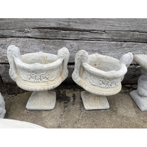 353 - A pair of ornate concrete fleur de lays two handled garden urns