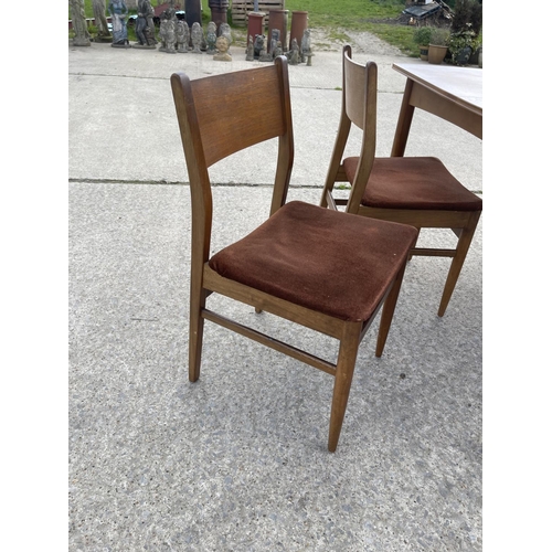 377 - a rectangular teak extending dining table together with four chairs