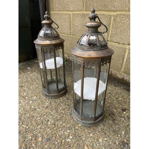 42 - A pair of copper and glass candle lanterns 61cm tall