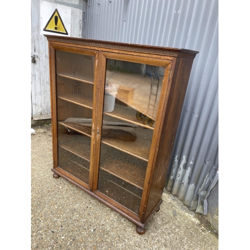 69 - A good quality glazed oak bookcase with four adjustable shelves 117x40x 140