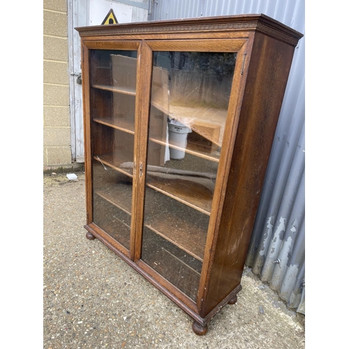 69 - A good quality glazed oak bookcase with four adjustable shelves 117x40x 140