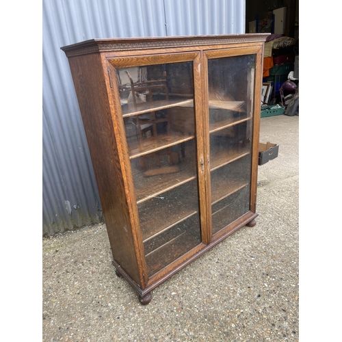 69 - A good quality glazed oak bookcase with four adjustable shelves 117x40x 140