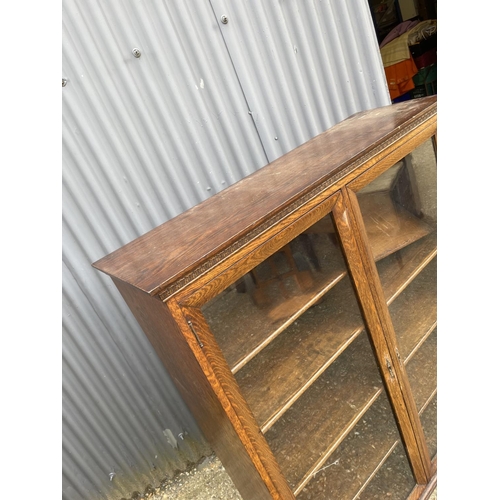 69 - A good quality glazed oak bookcase with four adjustable shelves 117x40x 140