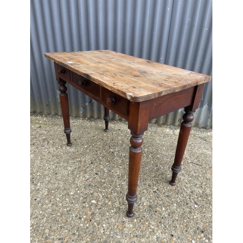 74 - A Victorian three drawer table with pine top  90x 50 x 75