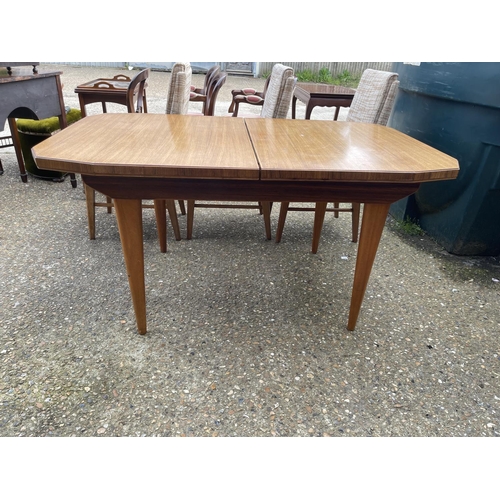 88 - A mid century extending rosewood dining table together with a set of six mid century chairs with ori... 