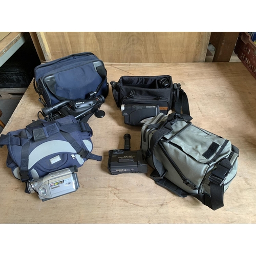 956 - Four camcorders with chargers and bag