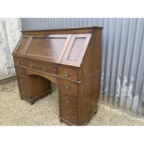 12 - An oak fall front writing desk with patent label 122cm wide