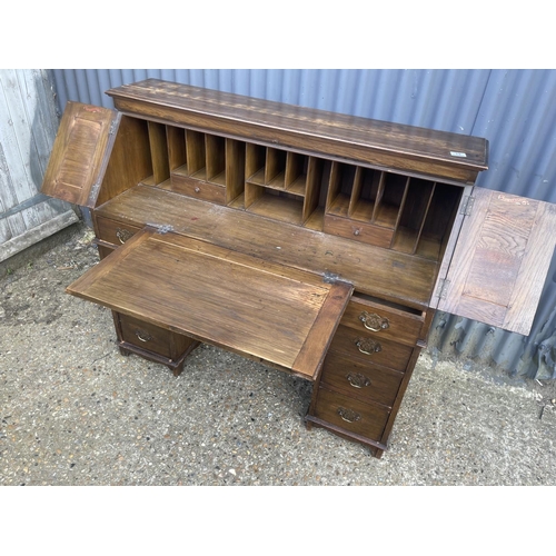 12 - An oak fall front writing desk with patent label 122cm wide