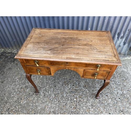 125b - A walnut three drawer lowboy with brass drop handles