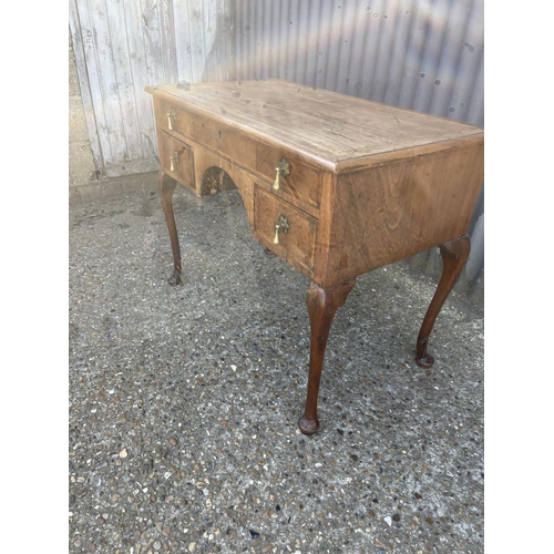 125b - A walnut three drawer lowboy with brass drop handles