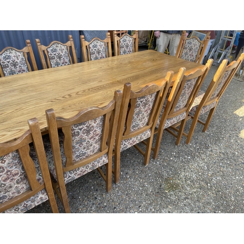 136 - A large light oak refectory style dining table together with a set of 12 upholstered oak framed dini... 