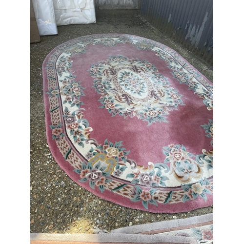 144 - A very large pink chinese rug together with two other chinese rugs