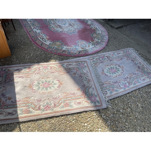 144 - A very large pink chinese rug together with two other chinese rugs