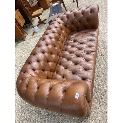 30 - A tan brown leather three seater chesterfield sofa with deep buttoned seat